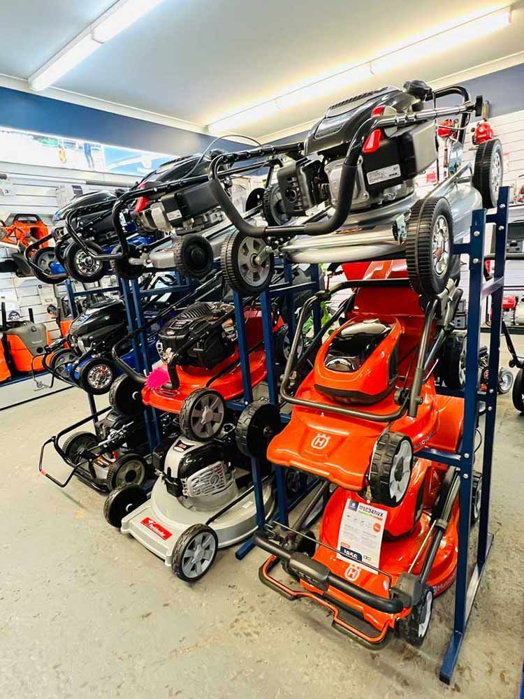 A Bunch of Lawn Mowers Are Sitting on Display in A Store — Mid Coast Mowers In Taree, NSW