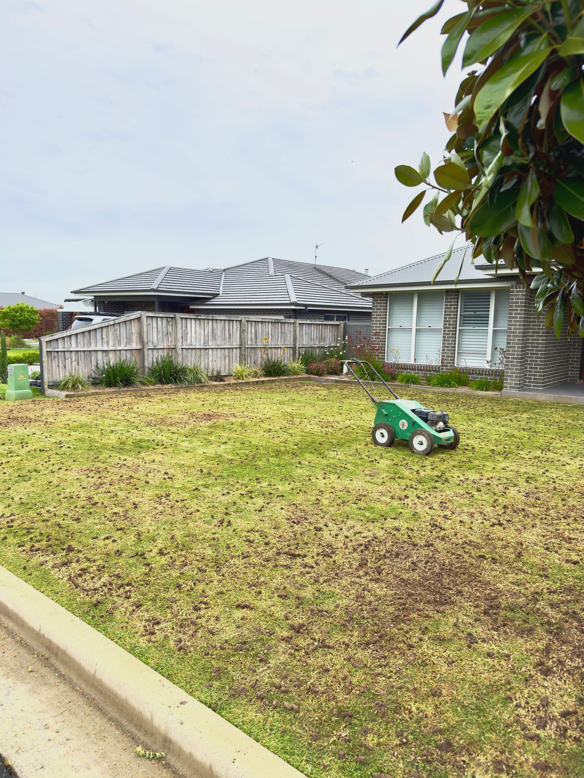 Person spraying lawn with a trailer labeled