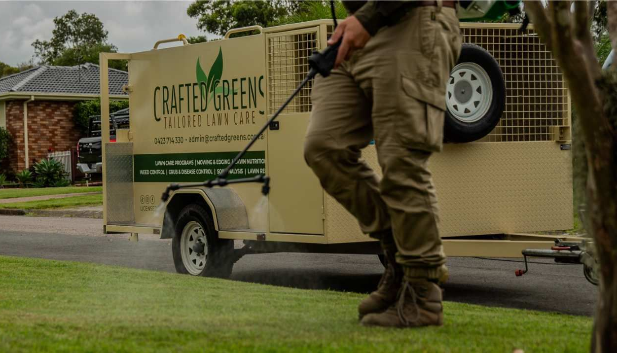 Person Spraying Grass With a Sprayer, Standing on a Green Lawn — Mow & Mulch Lawn & Garden Maintenance In Medowie, NSW