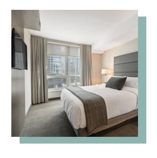 Modern hotel room with a bed, large window, and city view