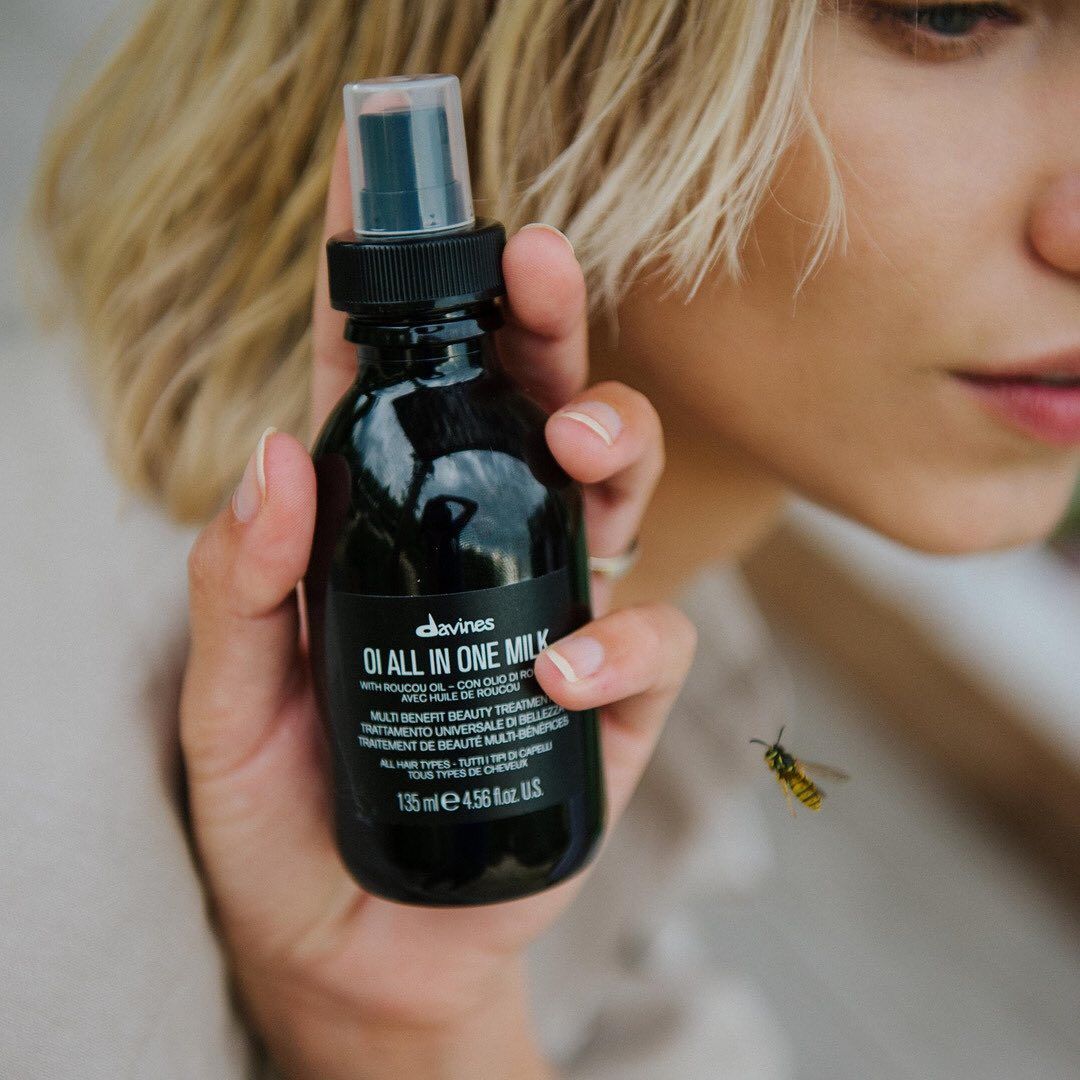 Eine Frau hält eine Flasche DA All-in-One-Spray