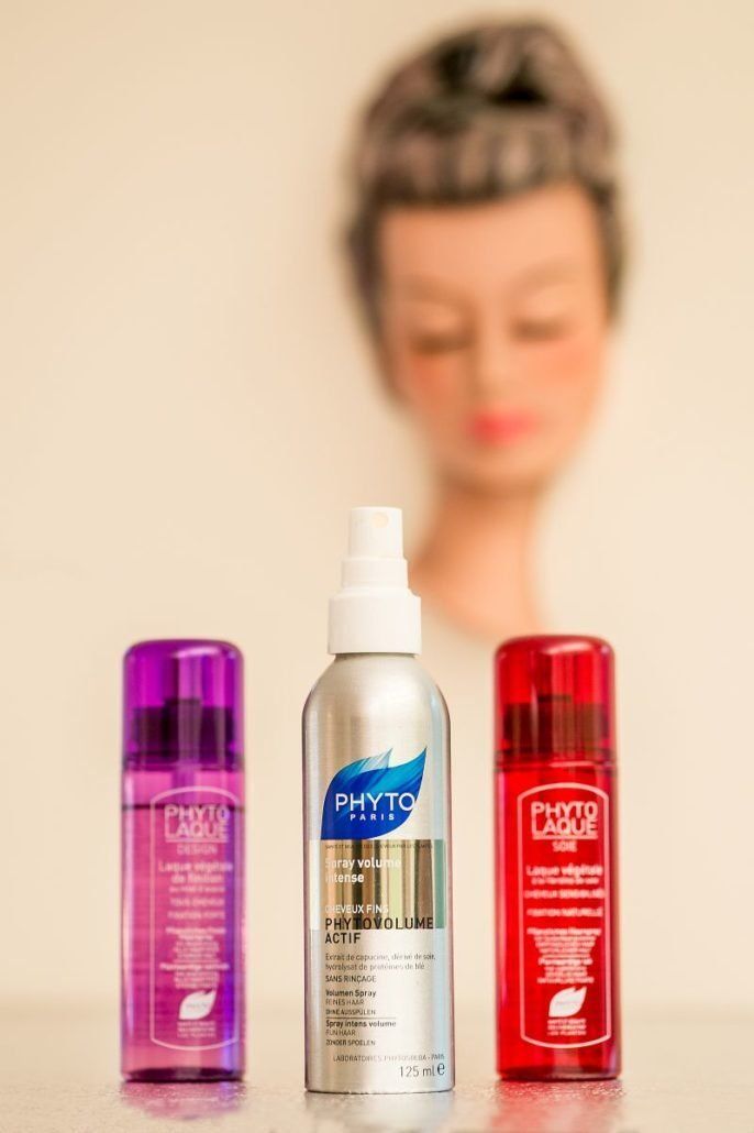 Auf einem Tisch stehen drei Flaschen Haarpflegeprodukte, im Hintergrund ist eine Schaufensterpuppe zu sehen.