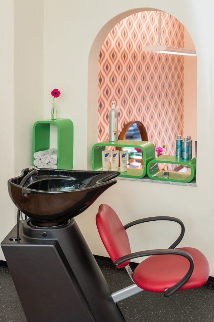 Ein Friseursalon mit einem roten Stuhl und einem Waschbecken