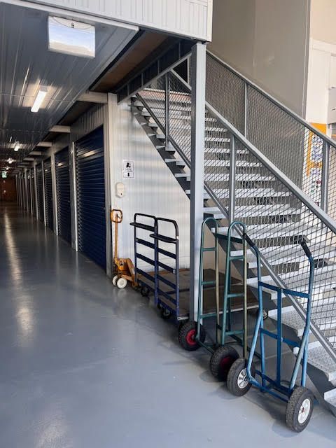 A row of storage units with a bicycle and boxes in them