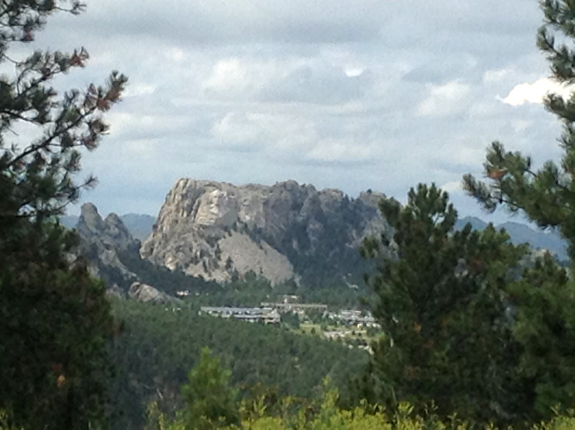 A mountain with a Mt Rushmore it is surrounded by trees