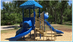 A blue playground with a slide and stairs in a park.