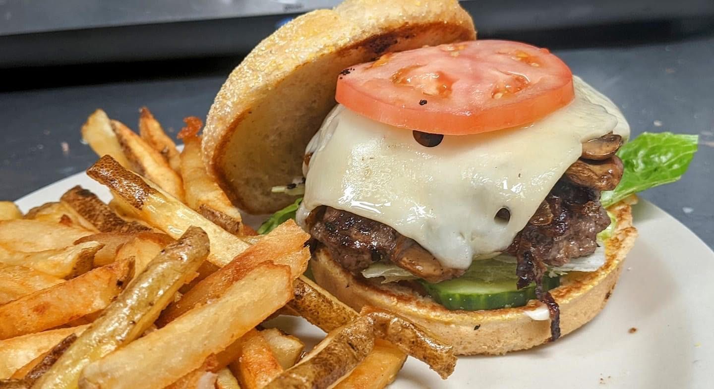 A hamburger and french fries on a white plate.