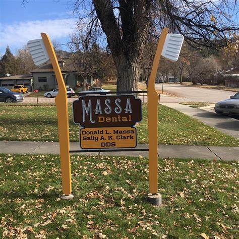 A sign for massa dental has two toothbrushes on it