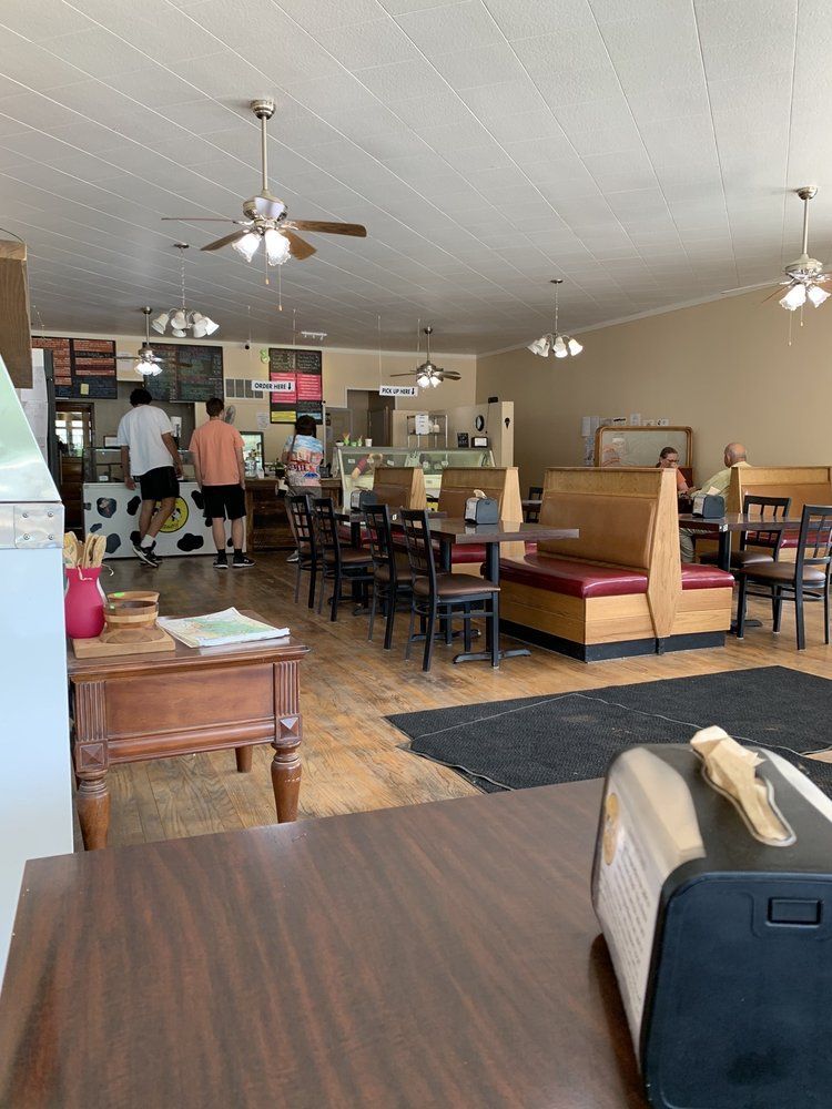 A restaurant with tables and chairs and a ceiling fan.