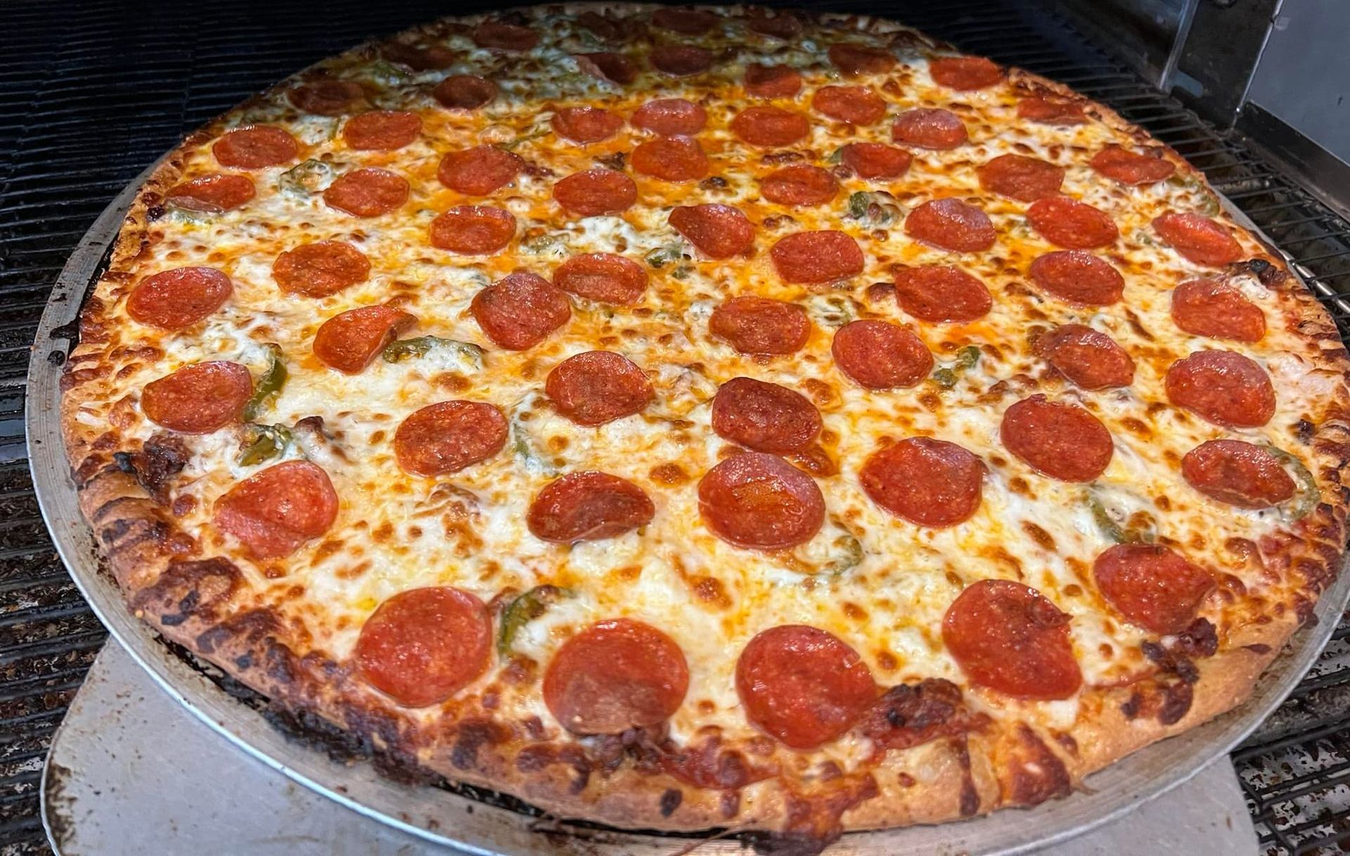 A person is holding a piece of pizza in their hand.