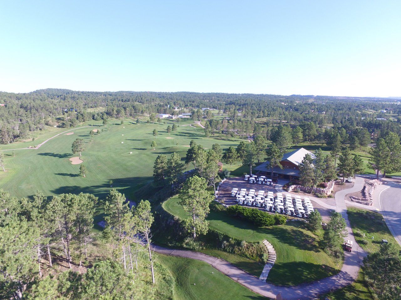 An aerial view of a golf course surrounded by trees.