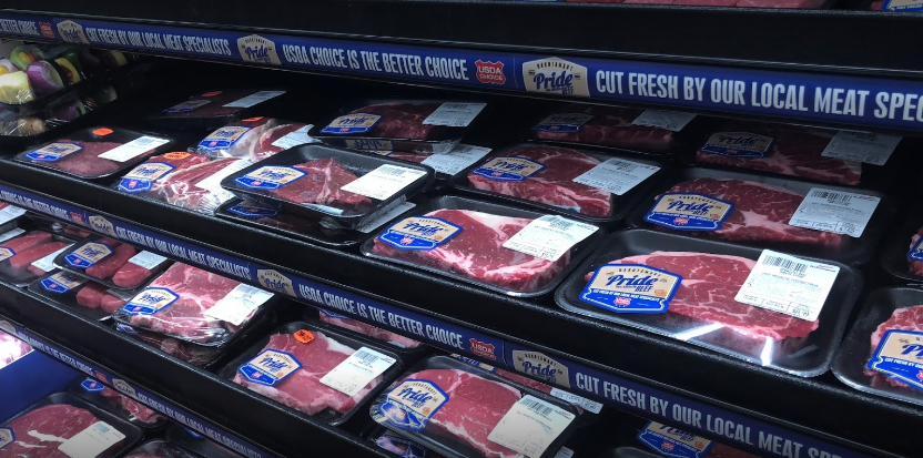 A shelf of meat in a grocery store with a sign that says `` cut fresh by our local meat spec ''.