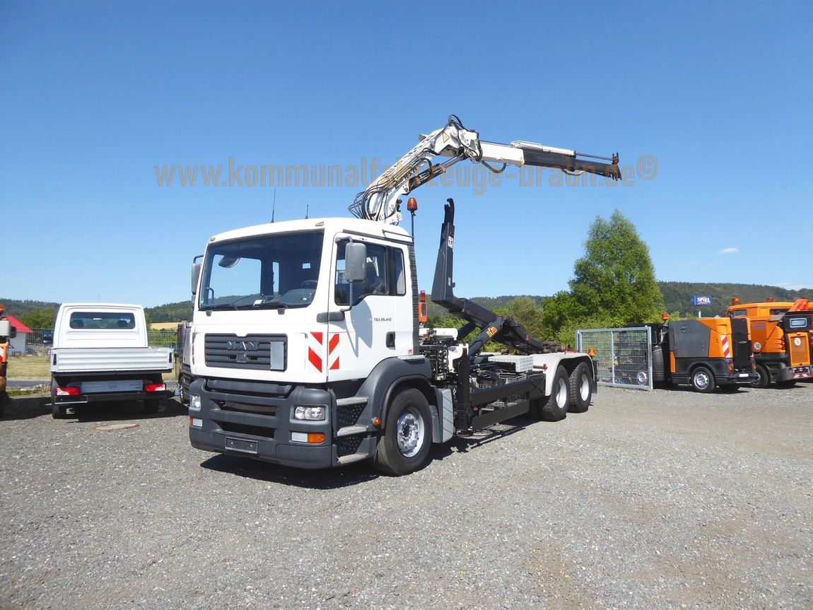 Ein Mann LKW mit einem Kran auf der Rückseite ist in einem Kies viel geparkt