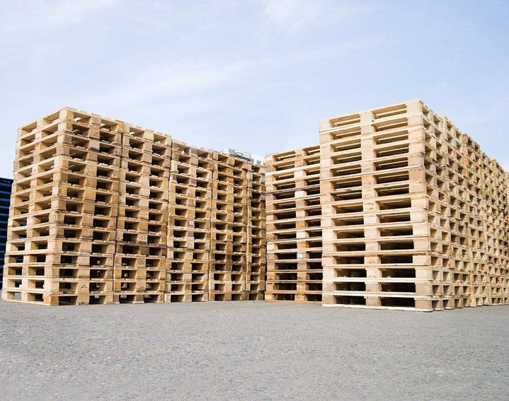 Young woman appending signature in digital mobile phone after receiving parcel from courier at home