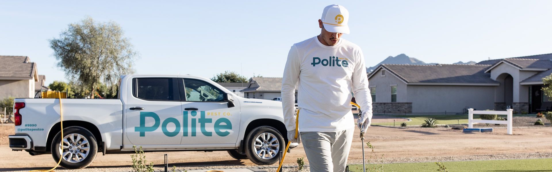 A man is walking in front of a white truck that says polite.