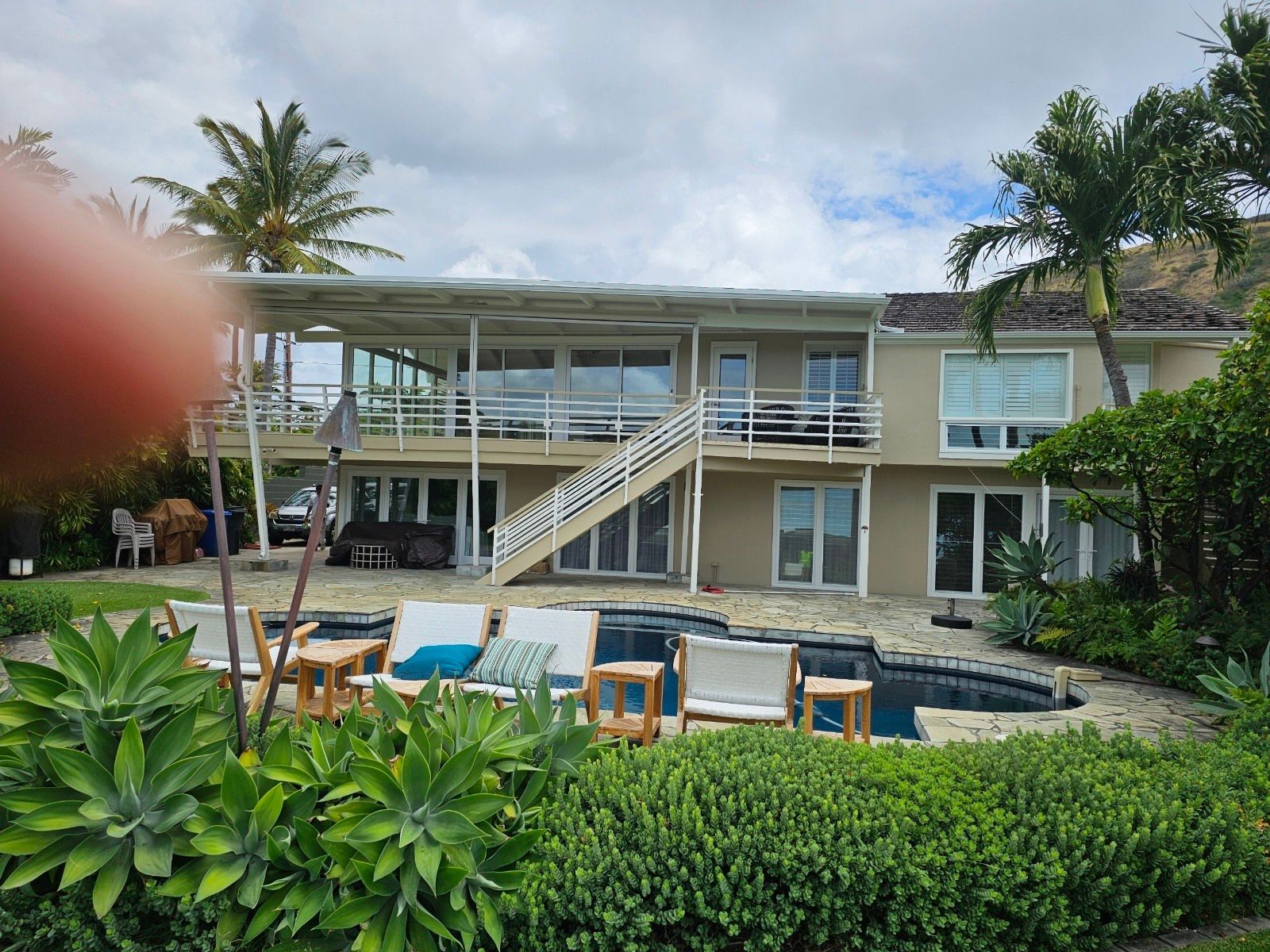 A large house with a swimming pool in front of it.