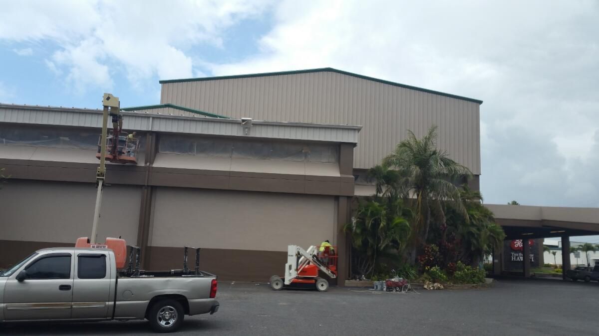A truck is parked in front of a large building.