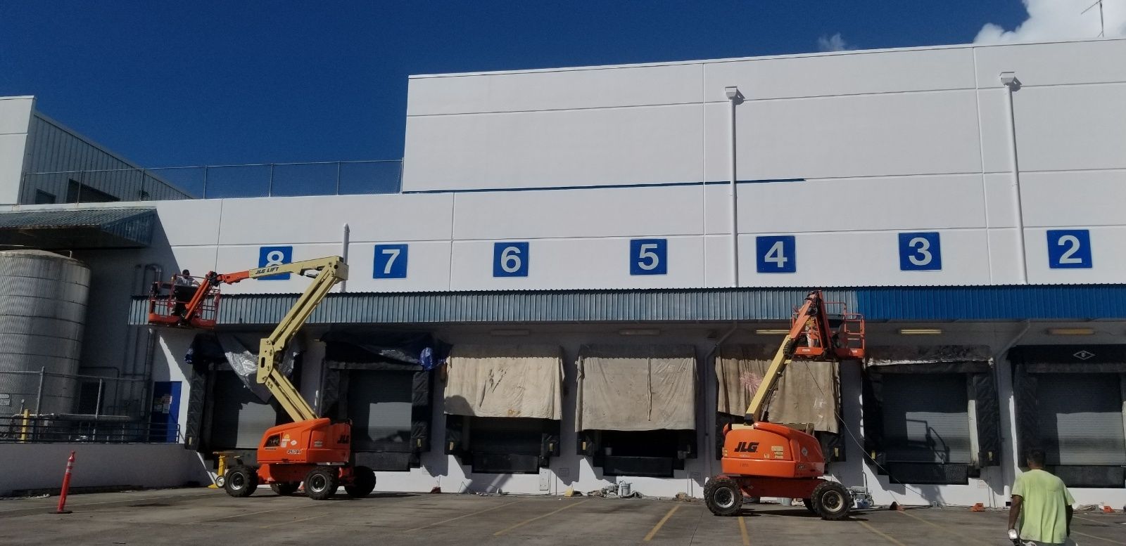 A warehouse with a lot of trucks parked in front of it.