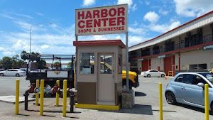 A parking lot with a sign that says harbor center shops and businesses.
