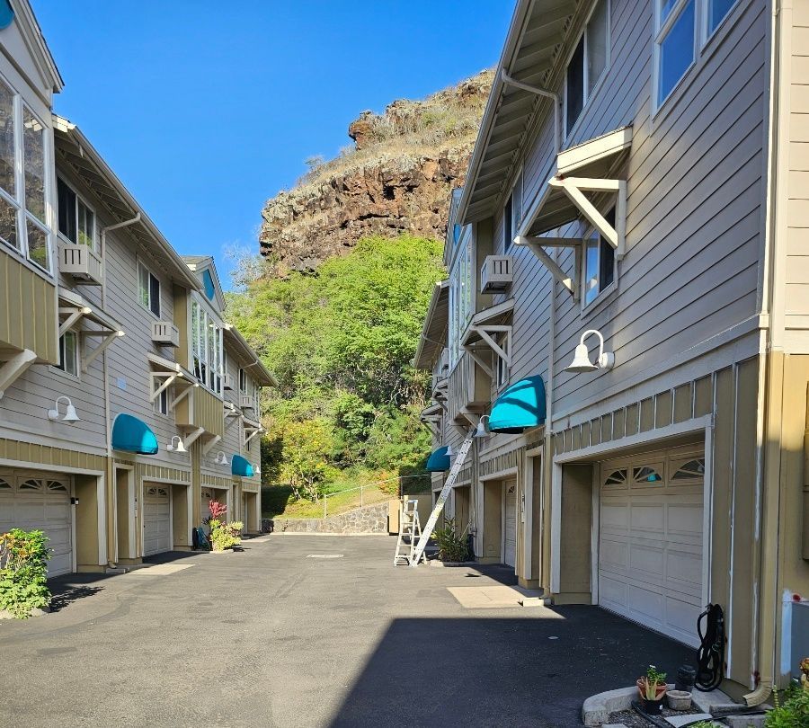 A row of apartment buildings with blue awnings on the garage doors