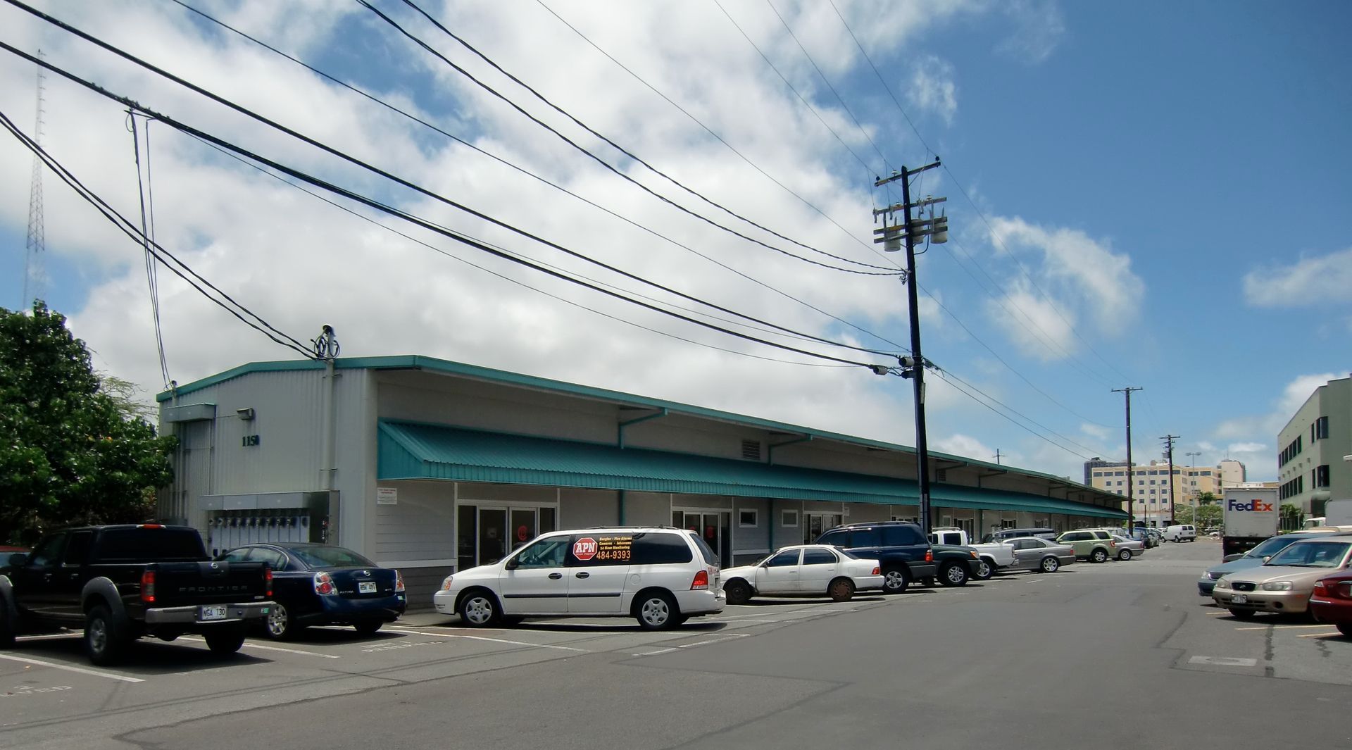 A row of cars are parked in front of a building