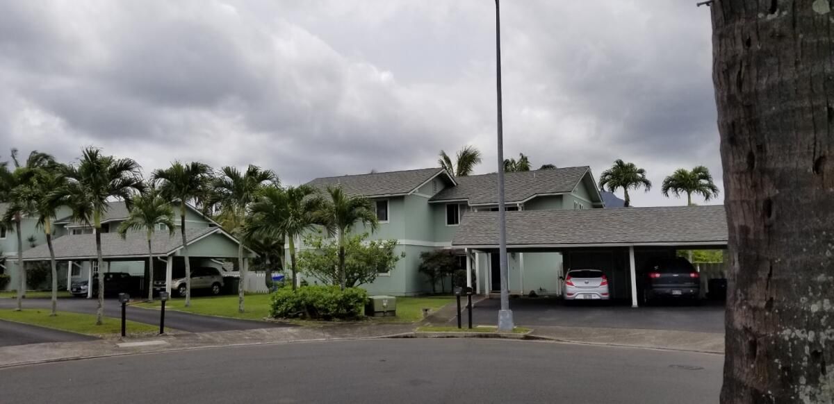 A house with a lot of cars parked in front of it.