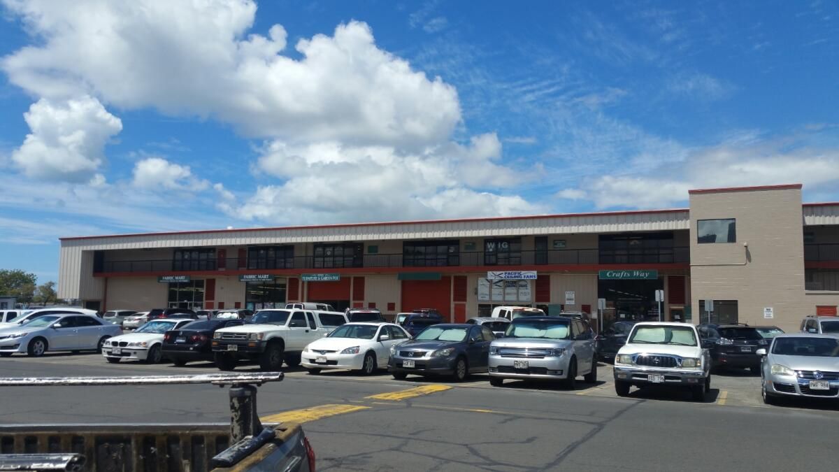 A lot of cars are parked in front of a building.