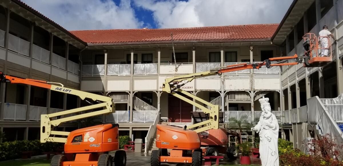 A statue of a woman is standing in front of a large building.