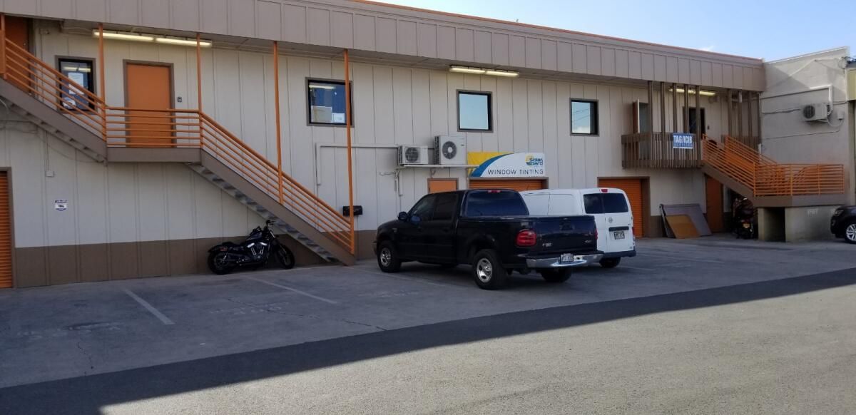 A building with stairs and cars parked in front of it