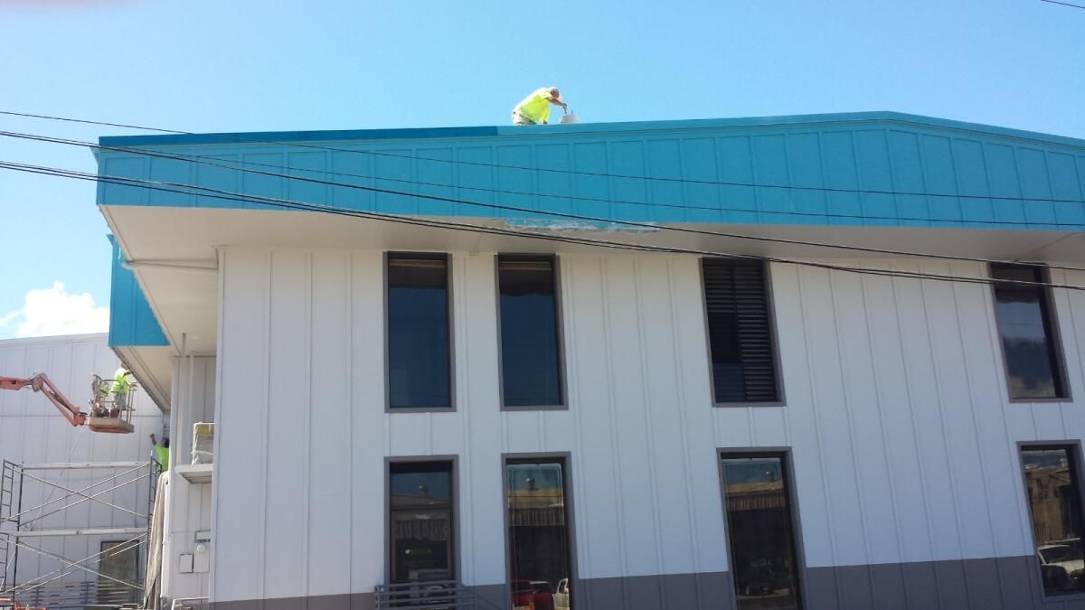 A man is working on the roof of a building.
