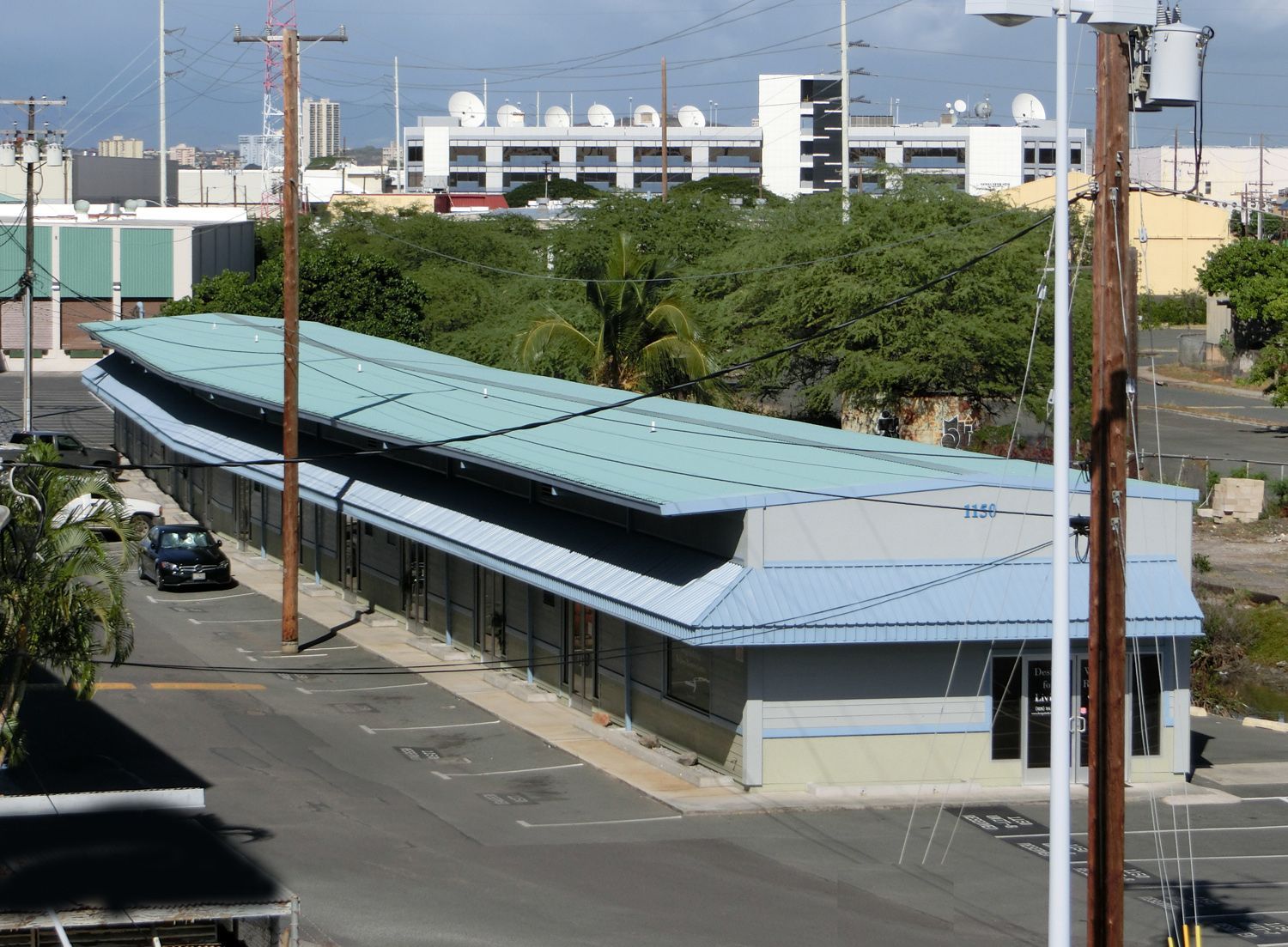 An aerial view of a building with a green roof in a parking lot.