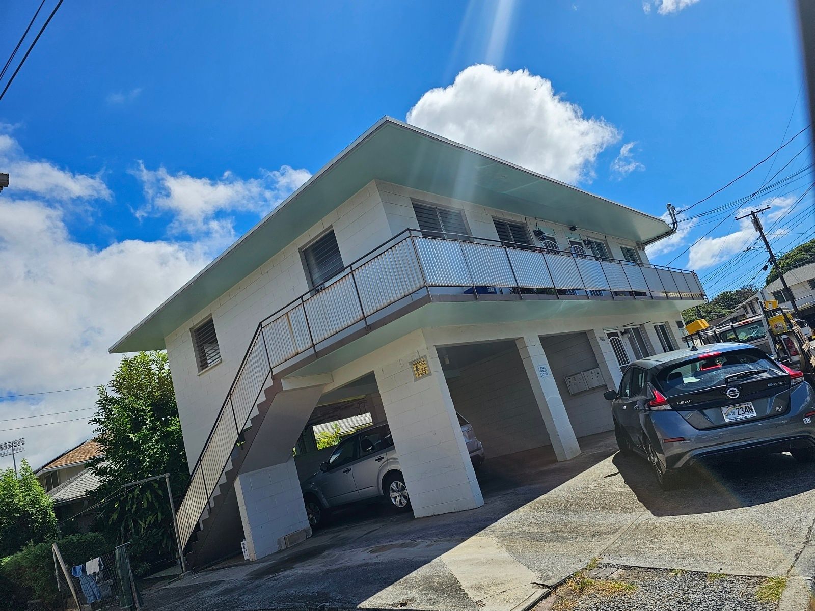 A white house with a car parked in front of it.