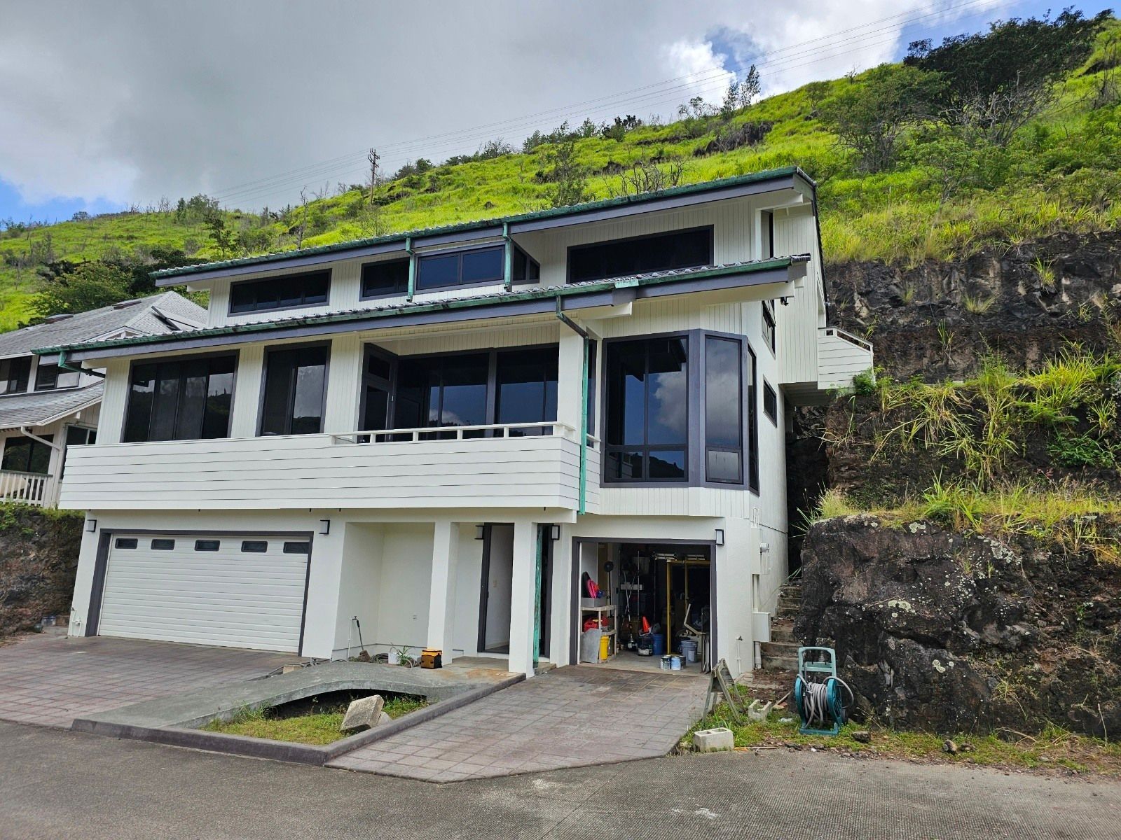 A large white house is sitting on top of a hill.