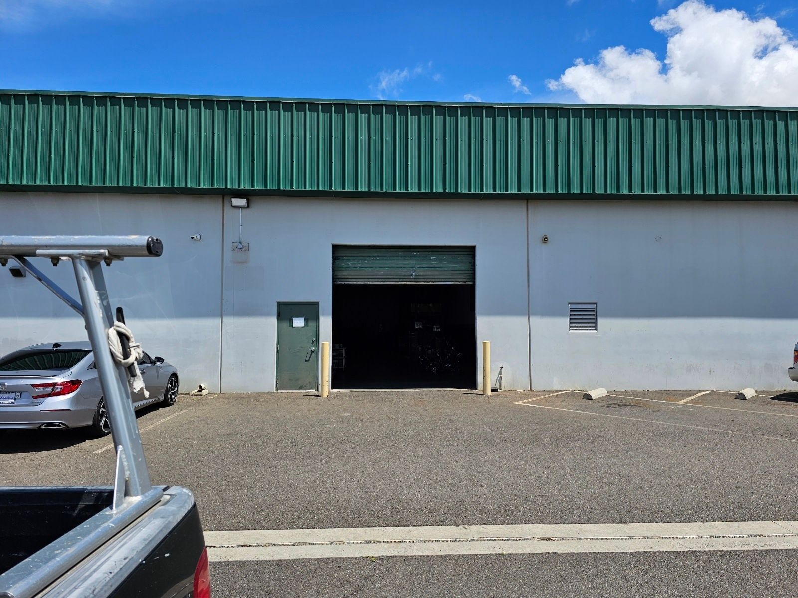 A truck is parked in front of a building with a green roof
