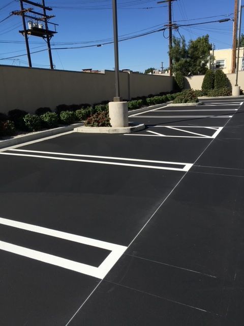 A black parking lot with white lines on it
