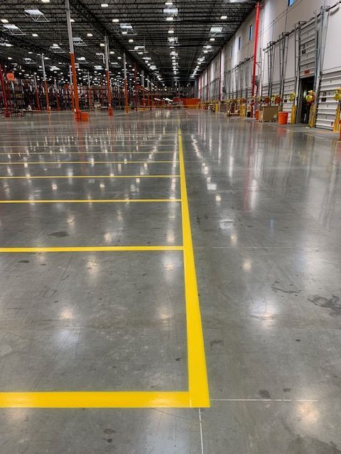 A large warehouse with a yellow line on the floor.
