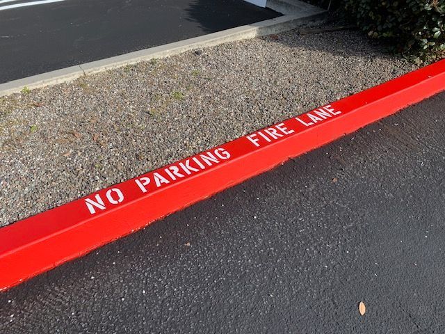 A red curb with the words no parking fire lane painted on it