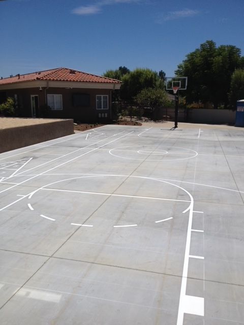 A basketball court with a house in the background
