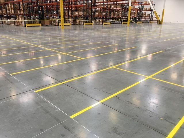 A large warehouse with yellow lines on the floor