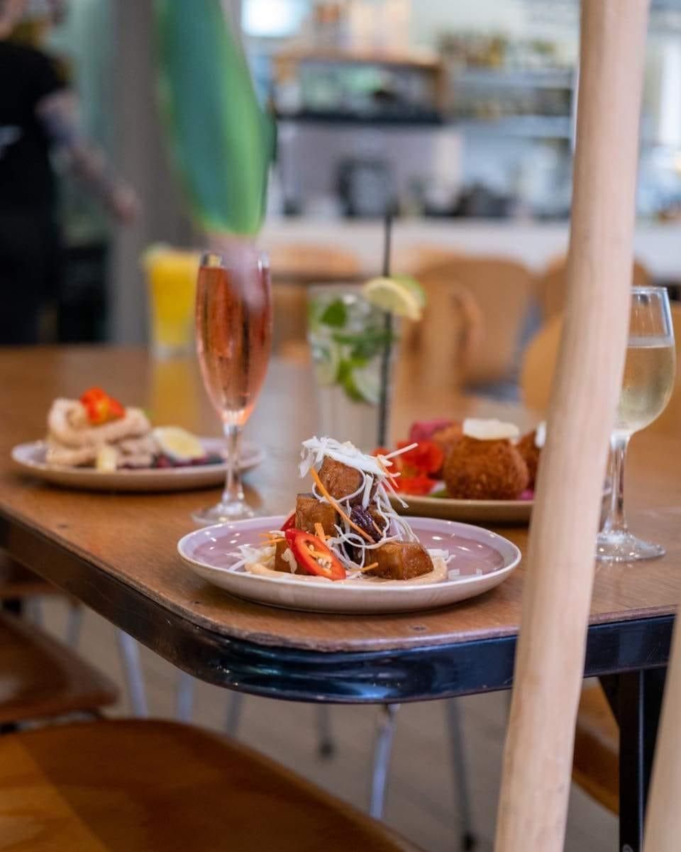 A Table With Plates Of Food And Wine Glasses On It — Top Point Café In East Gosford, NSW
