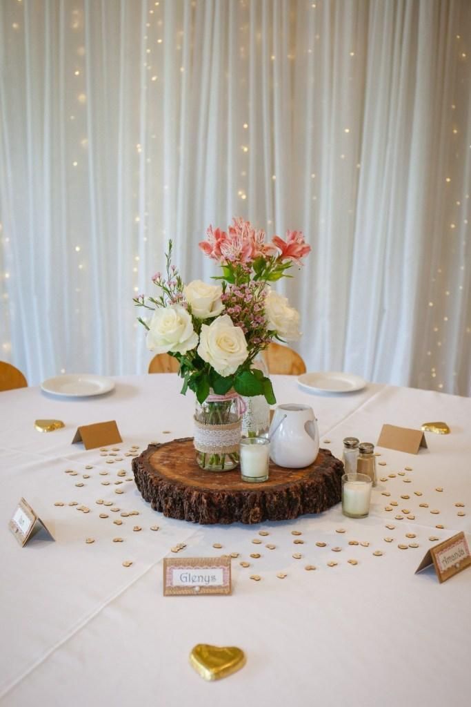 A Table With A Vase Of Flowers And Candles On It — Top Point Café In East Gosford, NSW