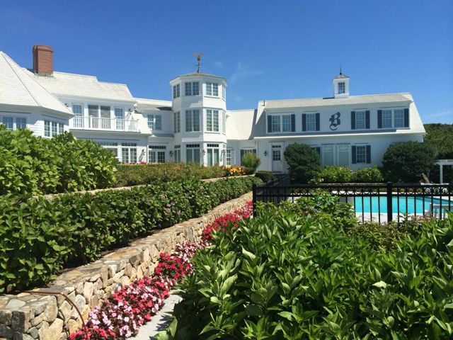 A large white house with a pool in front of it