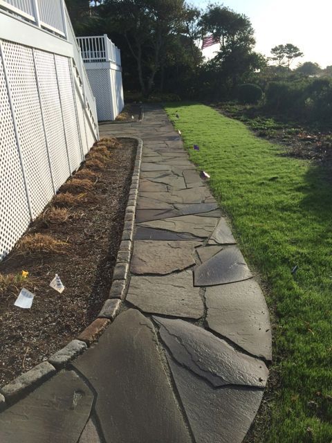 A stone walkway leading to a white house