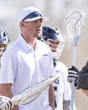 a lacrosse stick with a ball in the net .