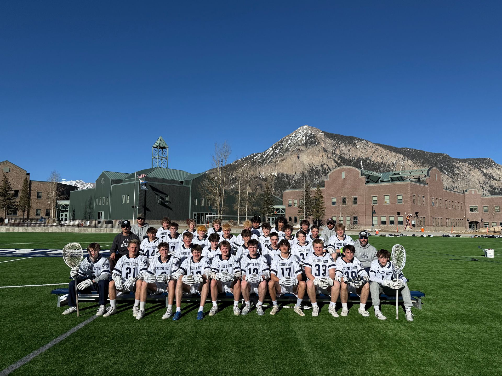a group of young men are playing lacrosse on a field .