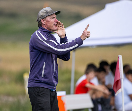 a man in a purple jacket is pointing at something