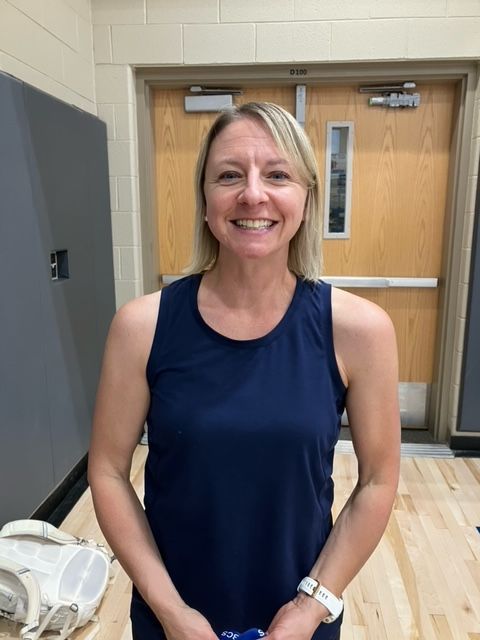 a person holding a volleyball behind a net