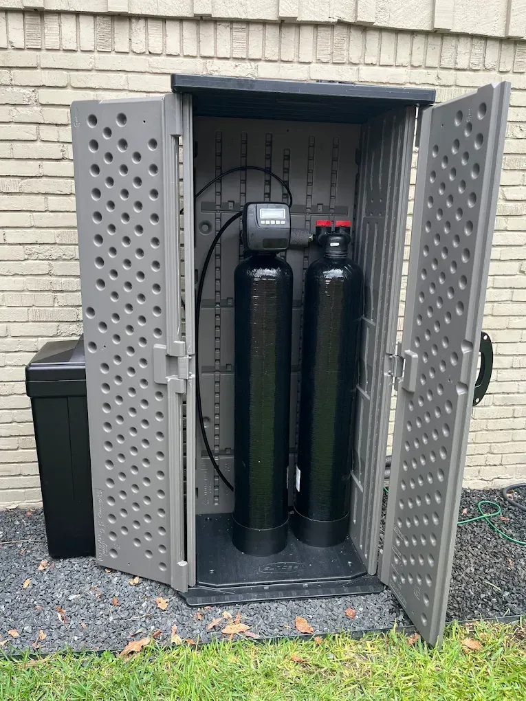 Two black cylinders are sitting inside of a plastic shed.