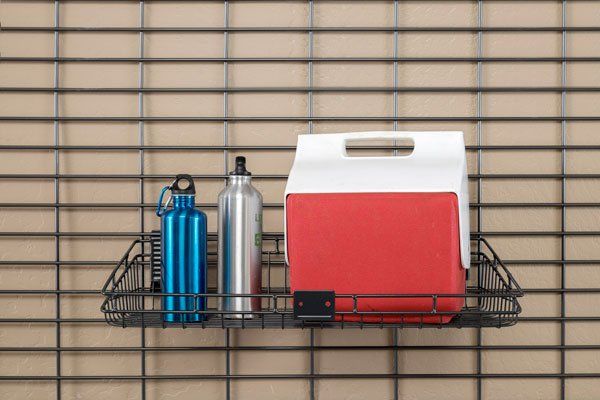 A shelf with water bottles and a cooler on it.