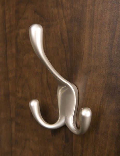 A silver hook is hanging on a wooden wall